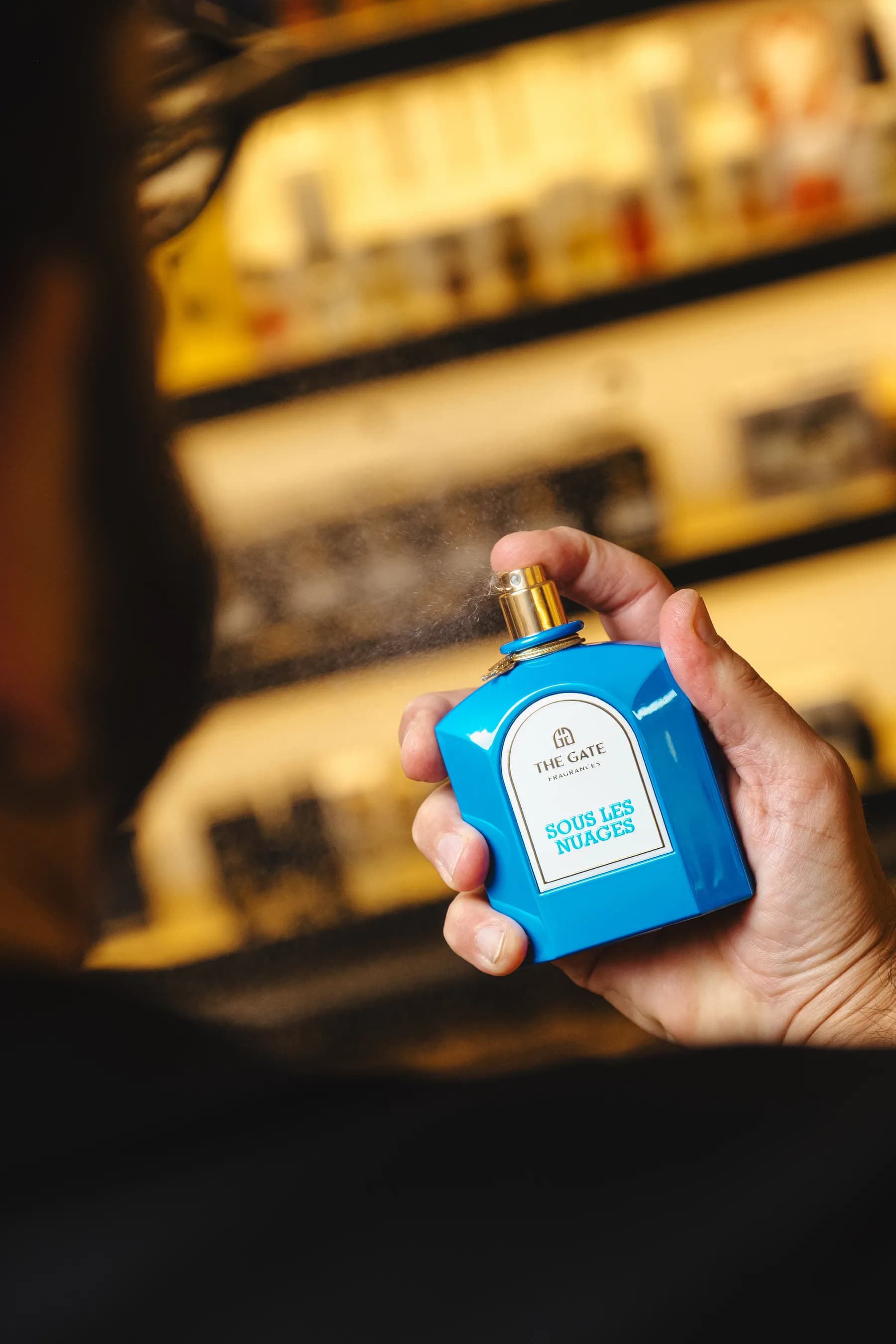 Flacone azzurro spruzzato davanti agli scaffali della boutique.