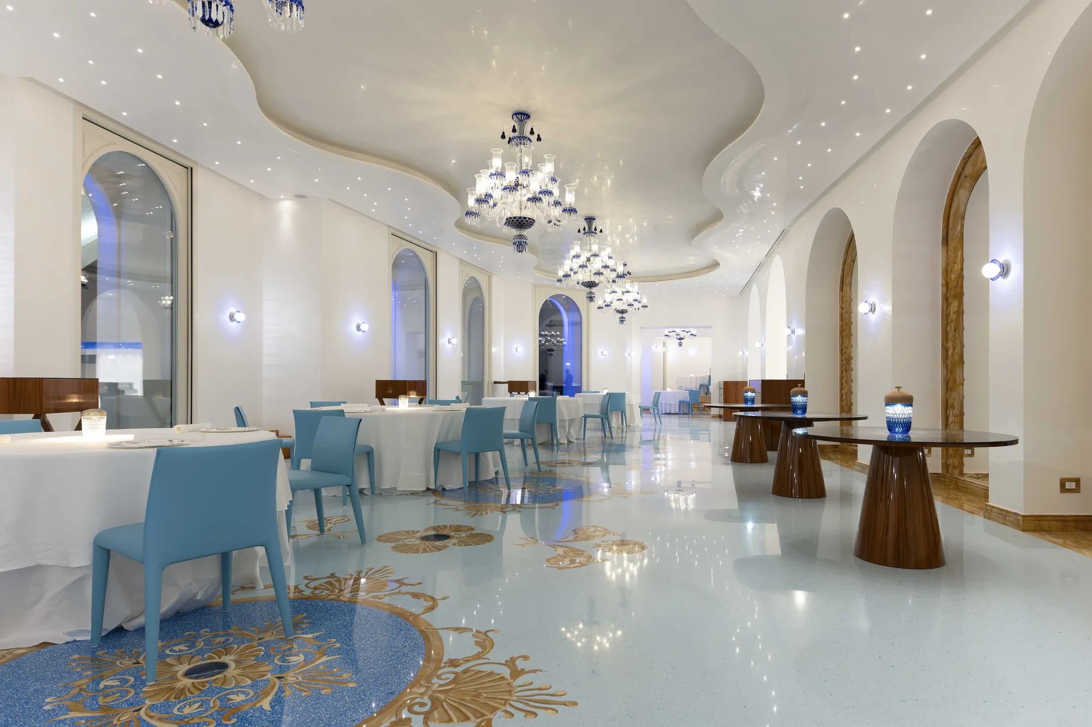 Sala del ristorante Casanova con lampadari in vetro blu e pavimento a mosaico.