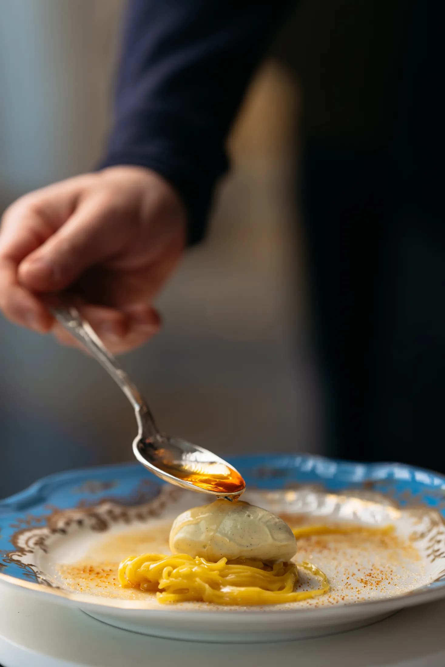 Chef completa un piatto con salsa versata al cucchiaio da Casanova.