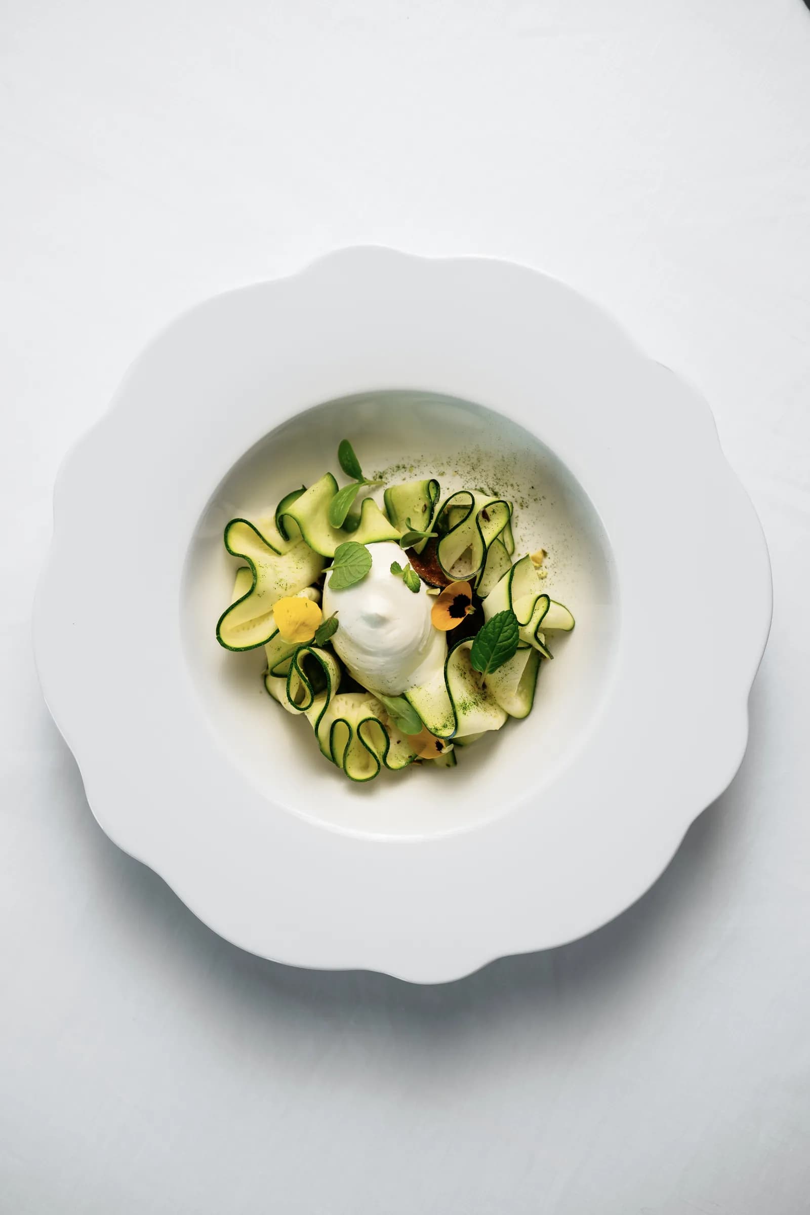 Piatto di zucchine e burrata di Grotta Palazzese visto dall'alto.