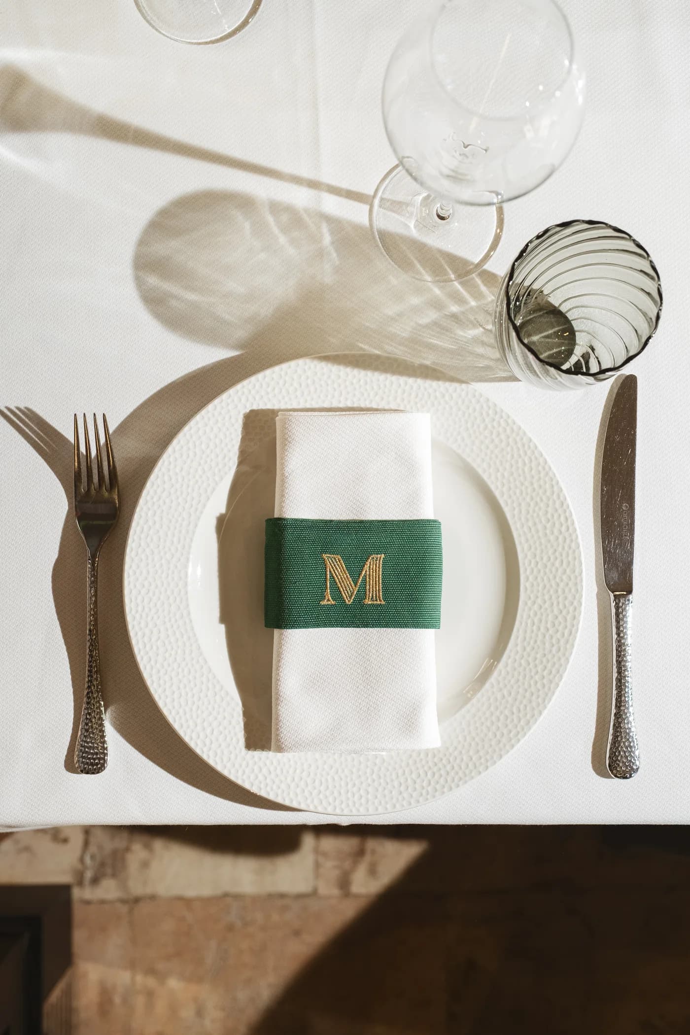Mise en place di Morus con tovagliolo verde e monogramma M.