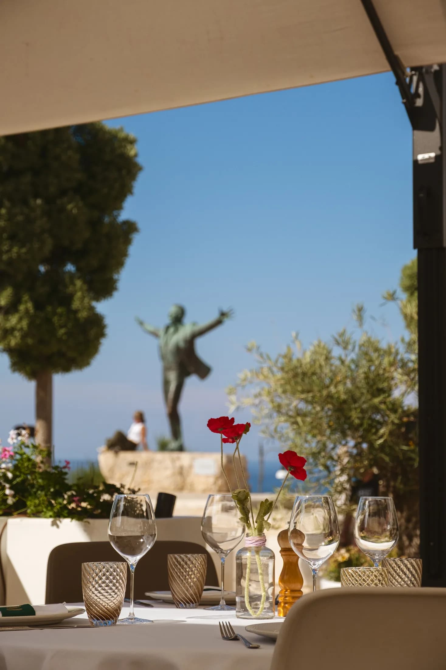 Terrazza di Morus con la statua di Modugno e il mare di Polignano a Mare.